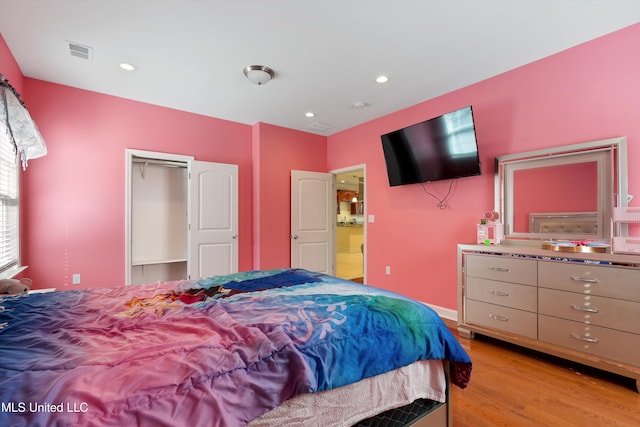 bedroom with light hardwood / wood-style flooring and a closet