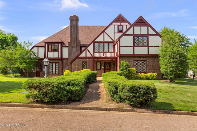 316 Meadow Creek Pl, Jackson, MS 39211 - tudor-style house with a front lawn, brick siding, stucco siding, and a chimney