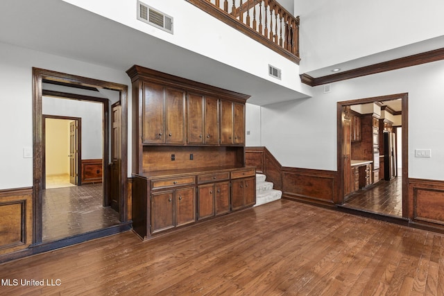 316 Meadow Creek Pl, Jackson, MS 39211 - unfurnished living room featuring wainscoting, dark wood-type flooring, and stairway