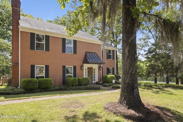 39 Moss Forest Cir, Jackson, MS 39211 - colonial-style house featuring a chimney, brick siding, a shingled roof, and a front yard