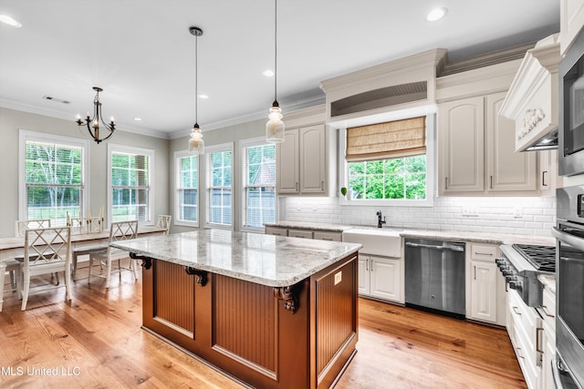 413 Miles Cv, Brandon, MS 39047 - kitchen with stainless steel appliances, a sink, a chandelier, a center island, and decorative backsplash