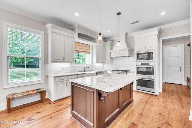 413 Miles Cv, Brandon, MS 39047 - kitchen with stainless steel appliances, a center island, white cabinetry, decorative backsplash, and crown molding