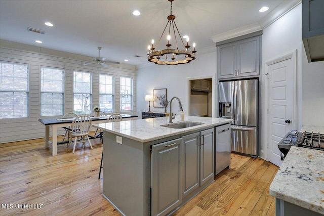 kitchen with gray cabinetry, sink, an island with sink, and stainless steel appliances