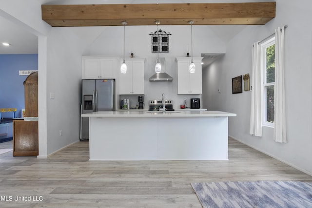 kitchen featuring an island with sink, light countertops, wall chimney exhaust hood, white cabinets, and stainless steel appliances