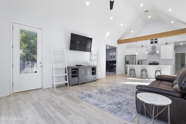 living area with high vaulted ceiling, ceiling fan, light wood finished floors, and visible vents
