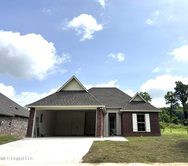 6 Hedges Plantation Pl, Natchez, MS 39120 - view of front of home featuring a shingled roof, concrete driveway, brick siding, a front yard, and an attached carport