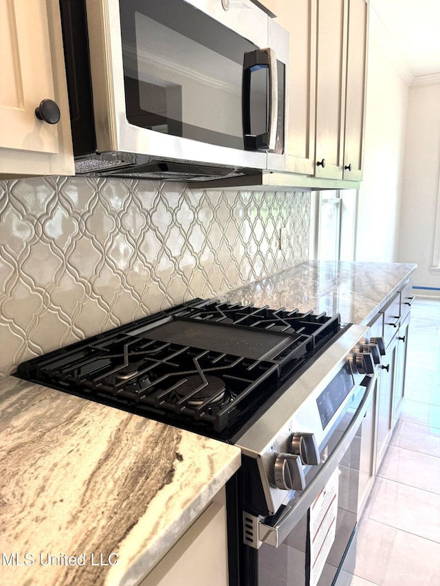 6 Hedges Plantation Pl, Natchez, MS 39120 - kitchen with appliances with stainless steel finishes, ornamental molding, backsplash, light stone countertops, and light tile patterned floors