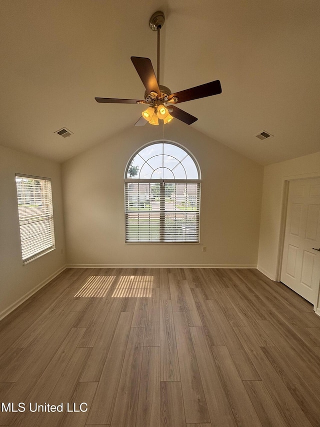 8911 Oak Branch Ln, Olive Branch, MS 38654 - empty room featuring vaulted ceiling, wood finished floors, healthy amount of natural light, a ceiling fan, and baseboards