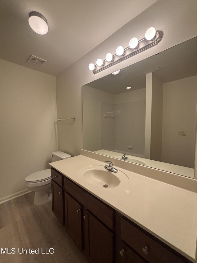 8911 Oak Branch Ln, Olive Branch, MS 38654 - bathroom with wood finished floors, toilet, vanity, and baseboards