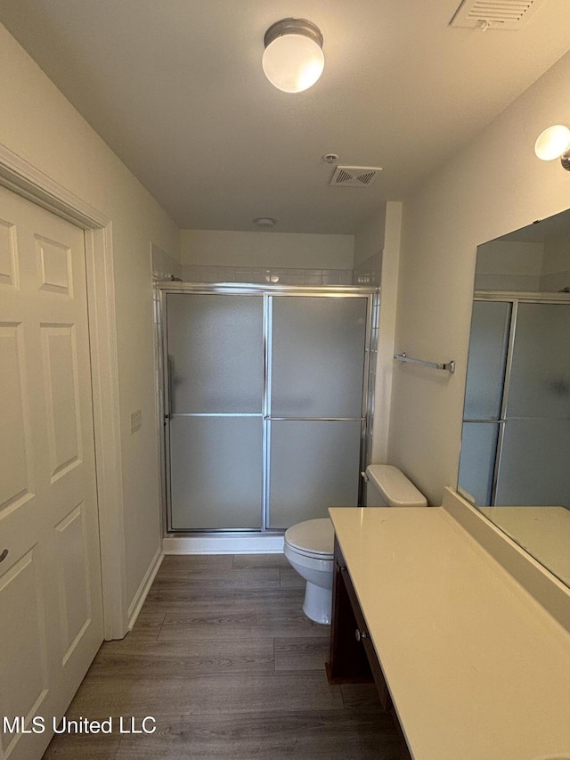 8911 Oak Branch Ln, Olive Branch, MS 38654 - bathroom featuring toilet, wood finished floors, vanity, and a shower stall