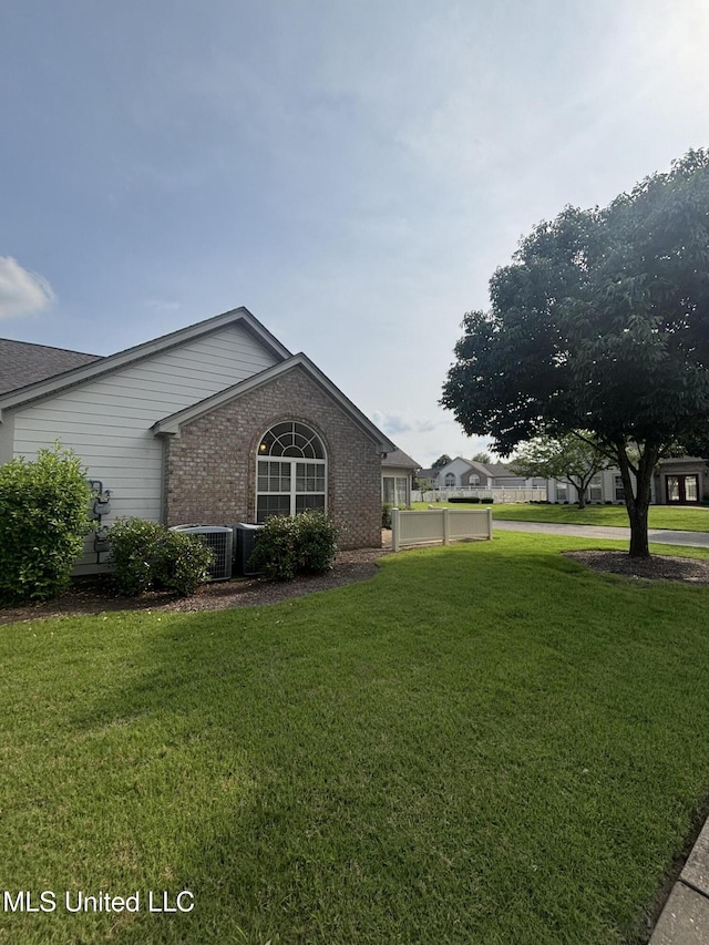 8911 Oak Branch Ln, Olive Branch, MS 38654 - view of side of home with brick siding, a yard, and central air condition unit