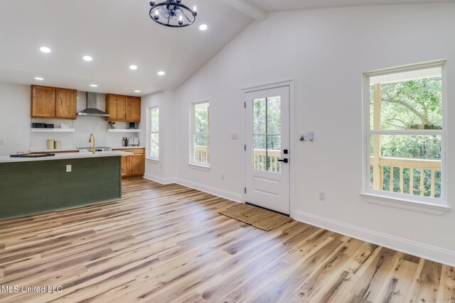11014 Gannet St, Bay Saint Louis, MS 39520 - kitchen featuring wall chimney range hood, brown cabinetry, light countertops, recessed lighting, and beamed ceiling