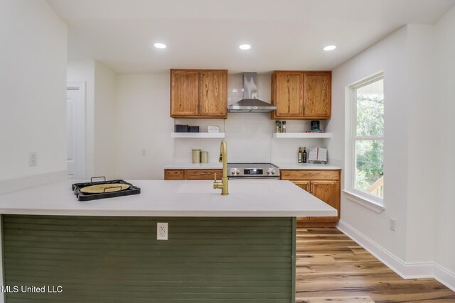 11014 Gannet St, Bay Saint Louis, MS 39520 - kitchen with wall chimney range hood, open shelves, light wood-style flooring, light countertops, and recessed lighting
