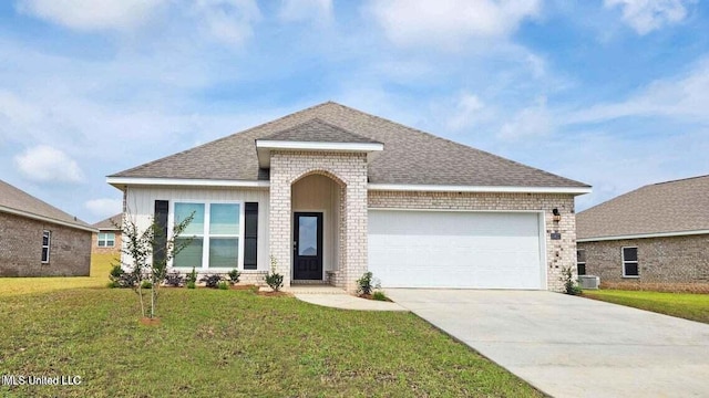 view of front of house with a garage, a shingled roof, driveway, a front yard, and brick siding
