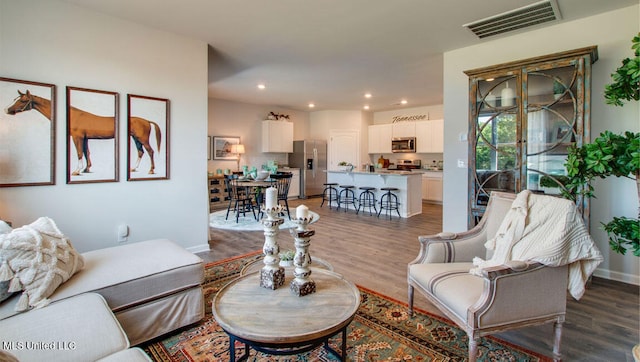 living area with wood finished floors, recessed lighting, and baseboards
