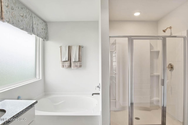 full bath with a bath, a stall shower, and vanity