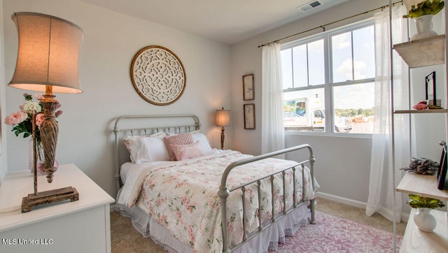 bedroom with light carpet, multiple windows, and baseboards