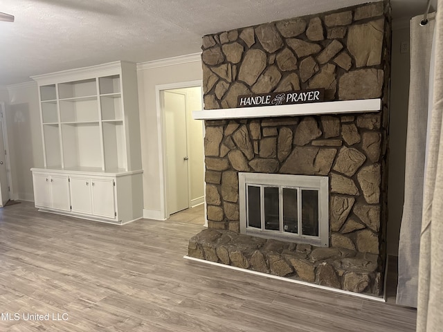 details featuring a stone fireplace, ornamental molding, a textured ceiling, and hardwood / wood-style flooring