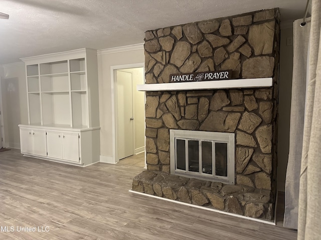 details with crown molding, wood-type flooring, a fireplace, and a textured ceiling