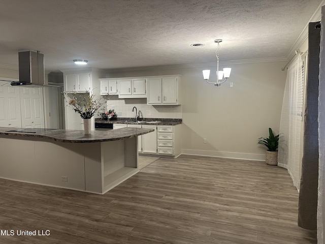 kitchen with white cabinetry, island range hood, dark hardwood / wood-style floors, kitchen peninsula, and pendant lighting