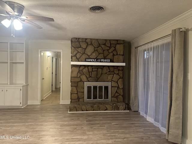 unfurnished living room with ornamental molding, a fireplace, light hardwood / wood-style flooring, and a textured ceiling