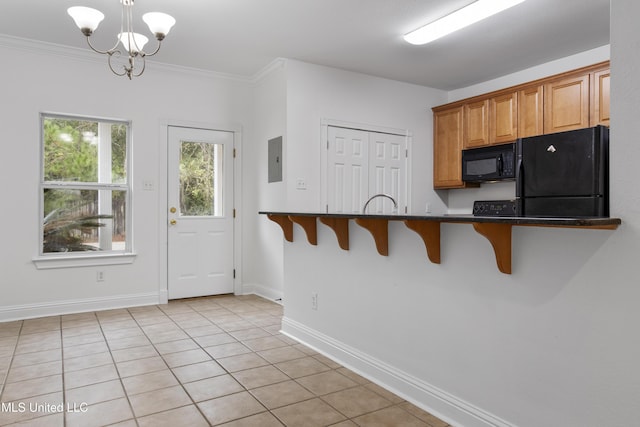 kitchen featuring hanging light fixtures, ornamental molding, a kitchen breakfast bar, electric panel, and black appliances