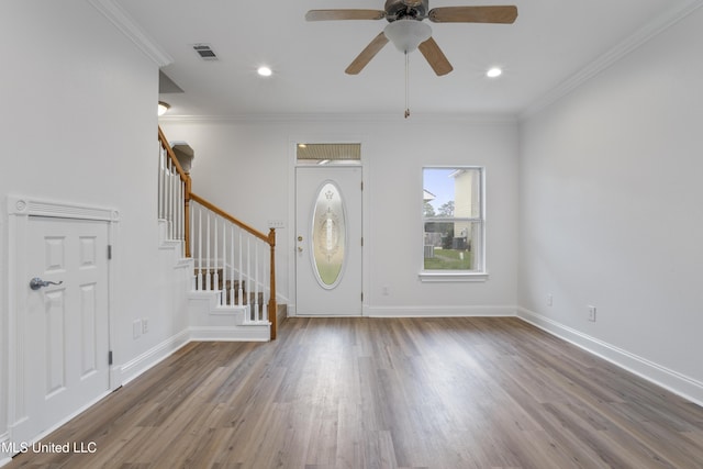 foyer with wood-type flooring, ornamental molding, and ceiling fan