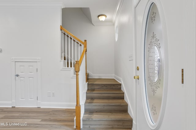 staircase with ornamental molding and wood-type flooring