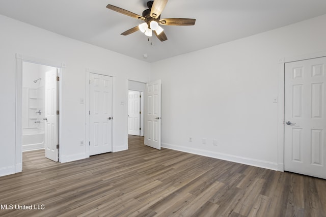 unfurnished bedroom with dark hardwood / wood-style floors, ceiling fan, and connected bathroom