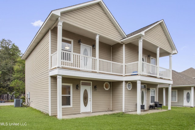 view of front facade featuring cooling unit, a balcony, a patio area, and a front lawn