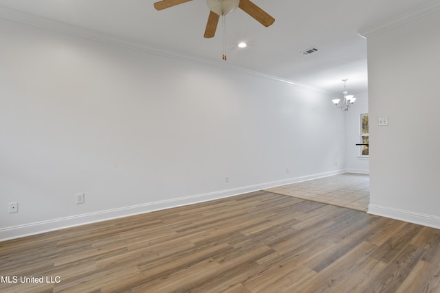 spare room with crown molding, ceiling fan with notable chandelier, and light wood-type flooring