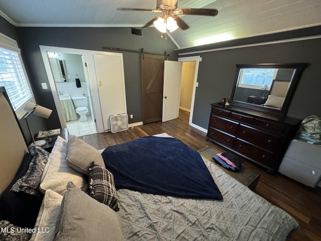 bedroom featuring wood finished floors, a barn door, baseboards, crown molding, and lofted ceiling