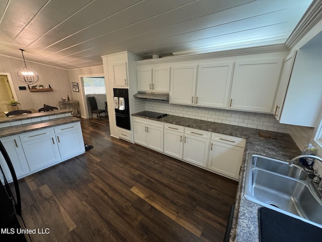 kitchen with dark wood finished floors, a sink, decorative backsplash, white cabinets, and dark countertops