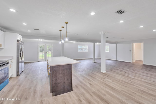 kitchen featuring french doors, appliances with stainless steel finishes, a kitchen island, light hardwood / wood-style floors, and white cabinetry