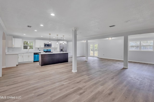 kitchen featuring appliances with stainless steel finishes, white cabinets, light hardwood / wood-style floors, a kitchen island, and hanging light fixtures