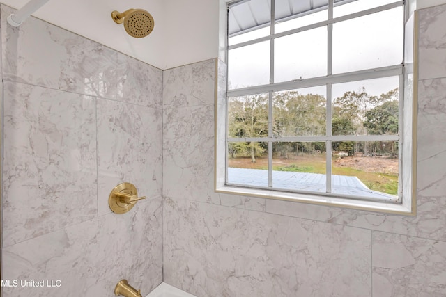 bathroom featuring plenty of natural light and a tile shower