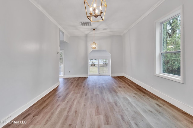 unfurnished living room featuring crown molding, a notable chandelier, and light wood-type flooring