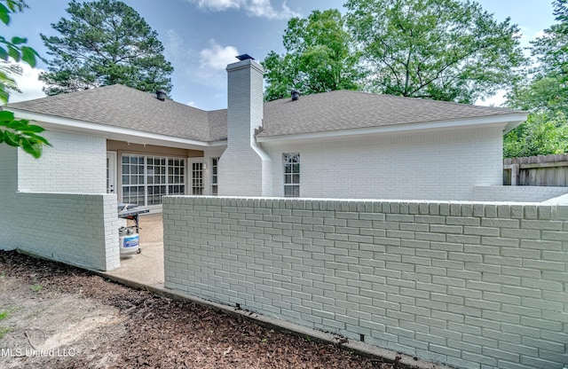 221 Boxwood Cir, Brandon, MS 39047 - back of property featuring brick siding, a chimney, and roof with shingles
