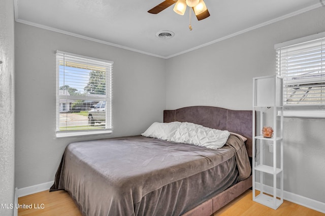 bedroom with ornamental molding, light hardwood / wood-style floors, and ceiling fan