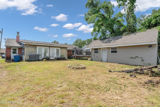 view of yard featuring french doors, a trampoline, and central AC unit