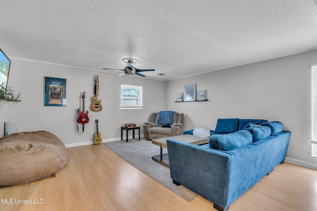 living room with ornamental molding, hardwood / wood-style floors, a textured ceiling, and ceiling fan