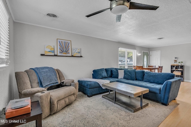 living room featuring ornamental molding, a textured ceiling, hardwood / wood-style flooring, and ceiling fan