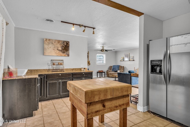 kitchen with a textured ceiling, dark brown cabinets, ceiling fan, light tile patterned floors, and stainless steel refrigerator with ice dispenser