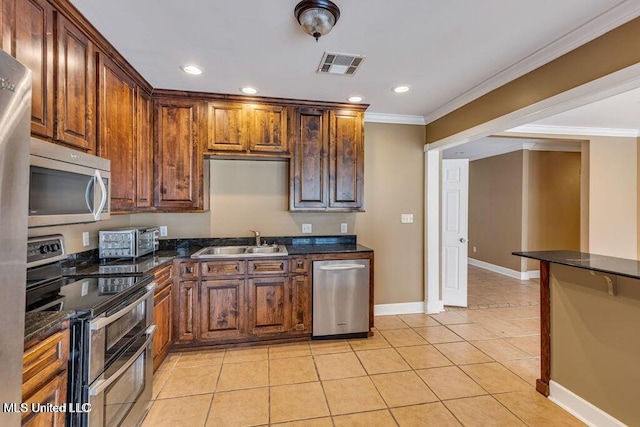 19 Poplar Cir, Gulfport, MS 39507 - kitchen with stainless steel appliances, a sink, ornamental molding, light tile patterned floors, and recessed lighting