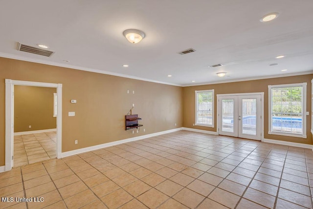 tiled empty room featuring a wealth of natural light, crown molding, and french doors