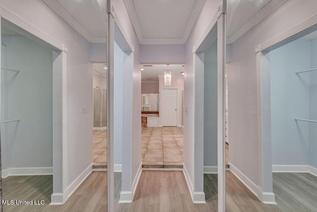 hallway featuring ornamental molding and light hardwood / wood-style flooring