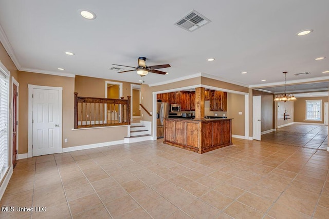 kitchen with decorative light fixtures, ceiling fan with notable chandelier, crown molding, and appliances with stainless steel finishes