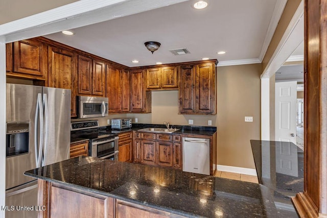 kitchen featuring dark stone counters, crown molding, sink, light tile patterned floors, and stainless steel appliances