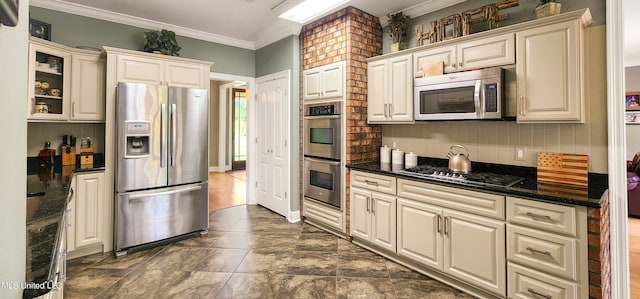 kitchen with dark stone countertops, ornamental molding, and appliances with stainless steel finishes