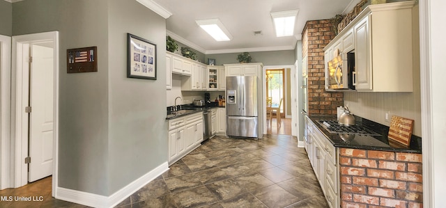 kitchen with white cabinets, sink, ornamental molding, and stainless steel appliances